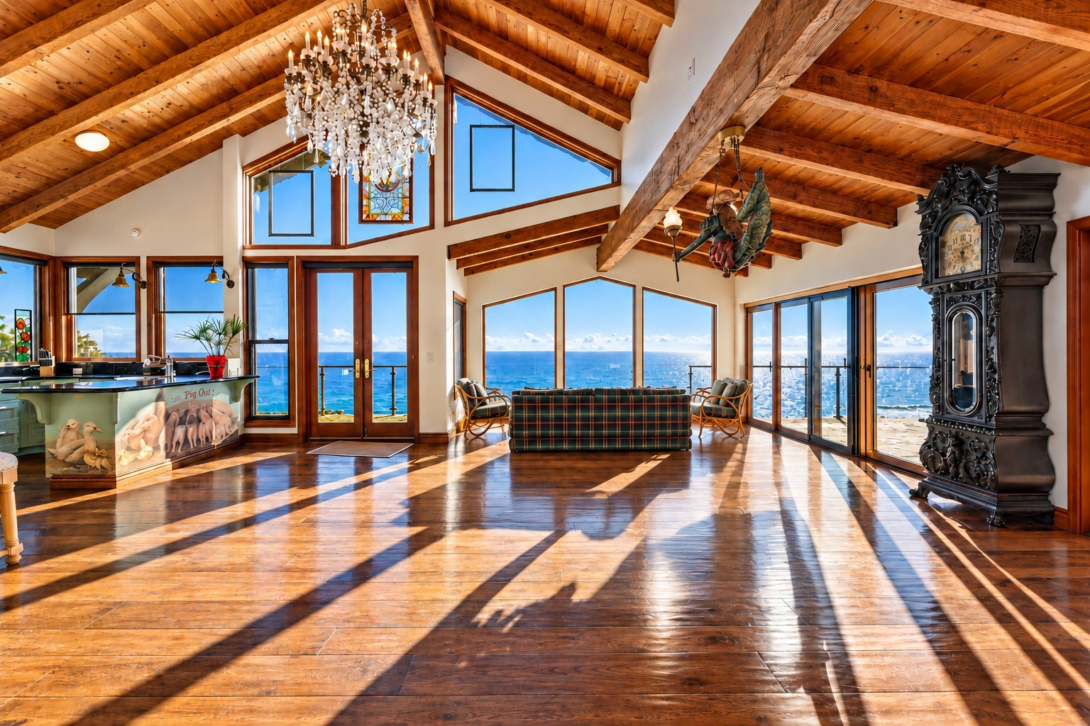Sunlit living room with vaulted timber ceiling and ocean views